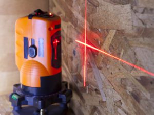 laser measurement level for construction works, small depth of sharpness, focus on a wall with a tag an orange laser measurement level for construction
